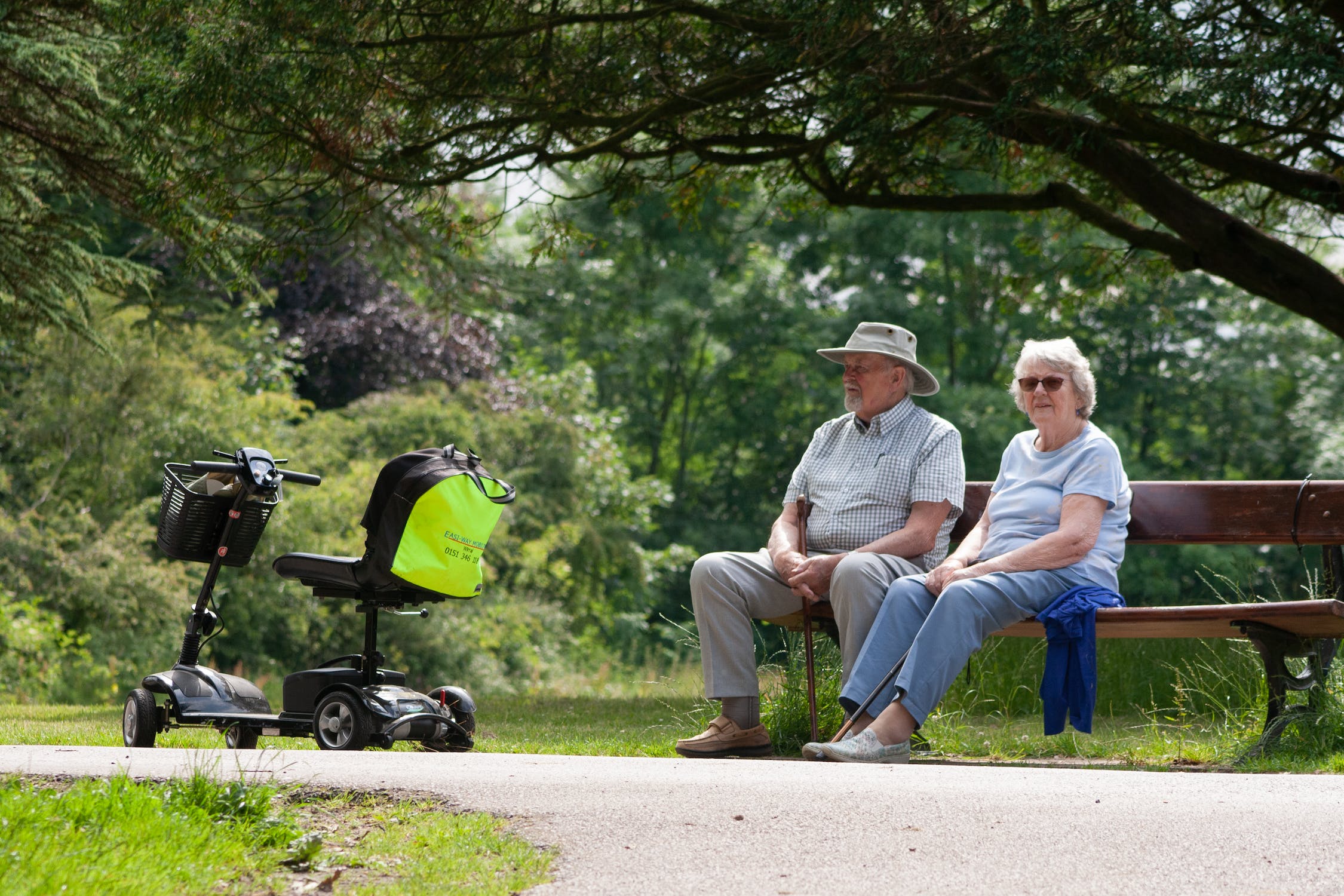 mobility scooter parked by an elderly couple in a park