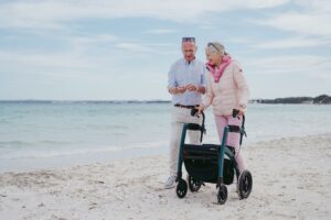 senior couples using a rollator outside by the seaside