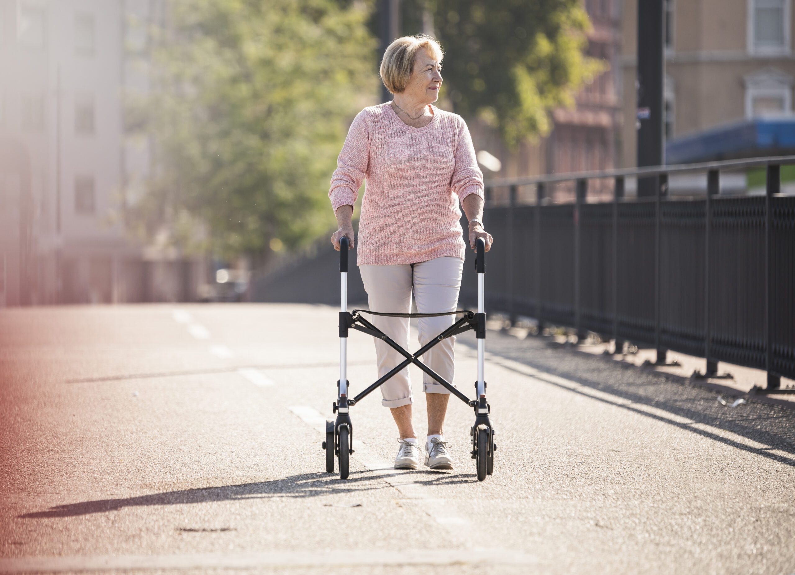 Senior woman with wheeled walker on footbridge in ware, herfordshire