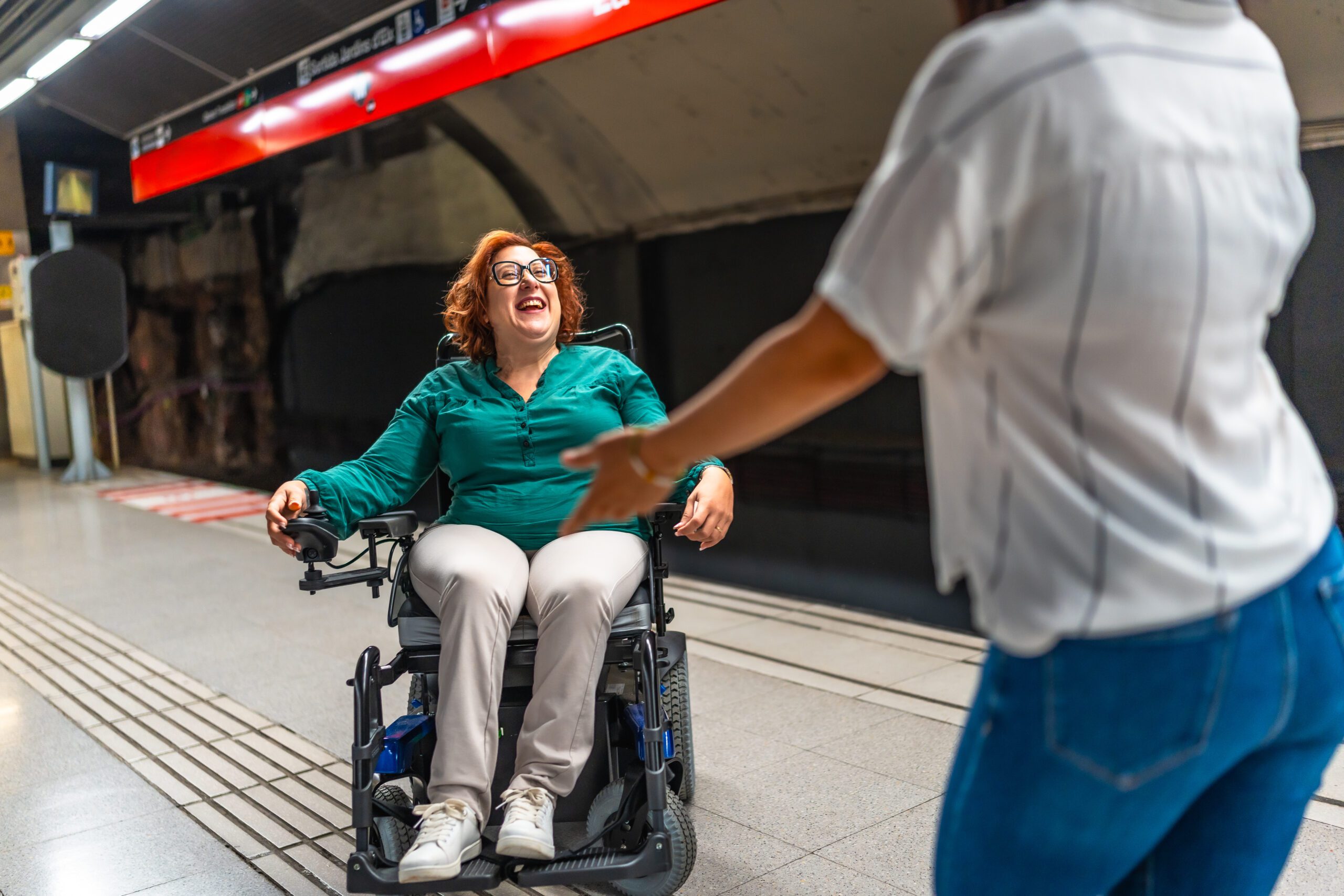 Happy meeting in the metro between a smiling disabled woman and friend