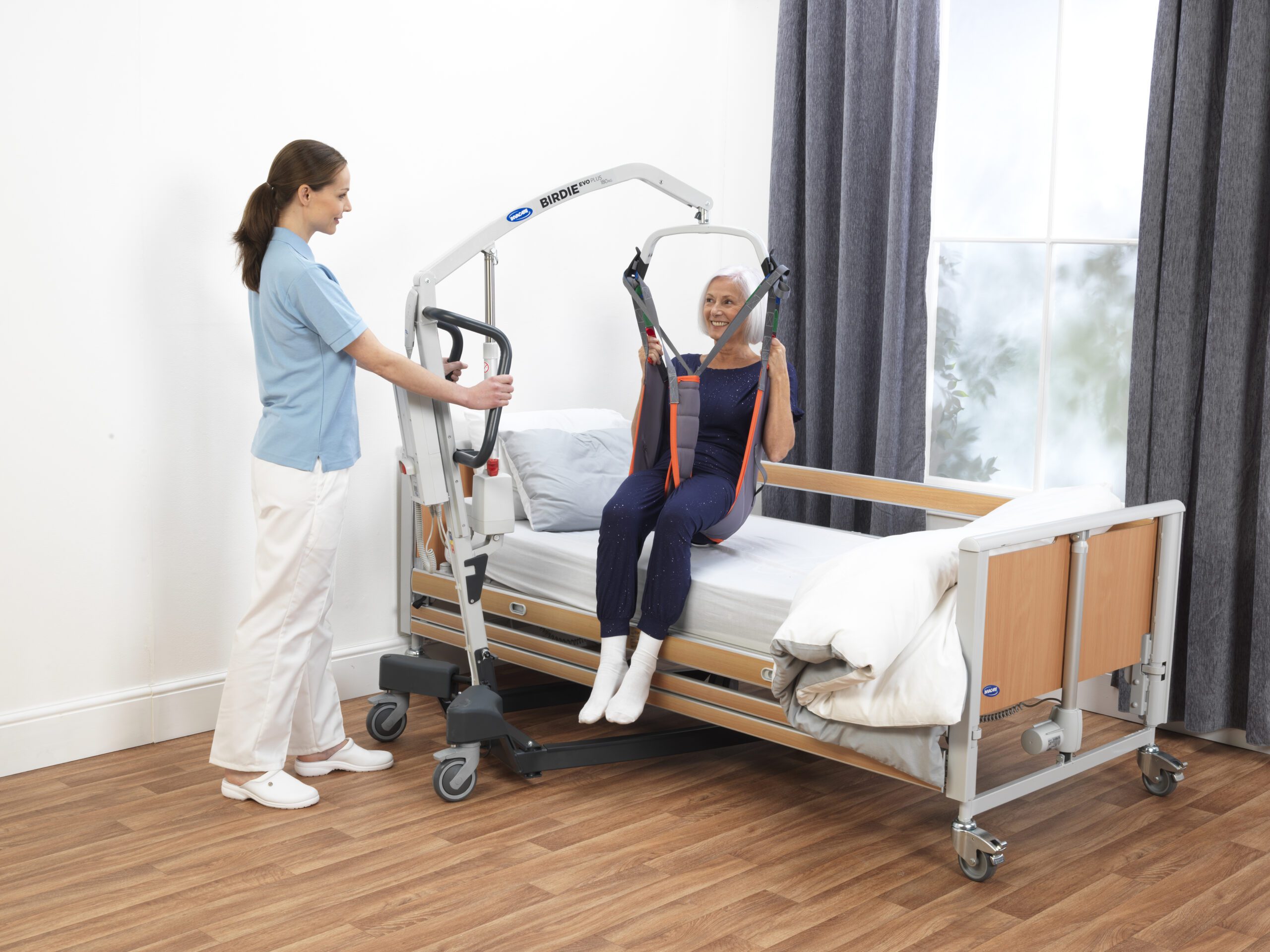 elderly person on hoist on hospital bed