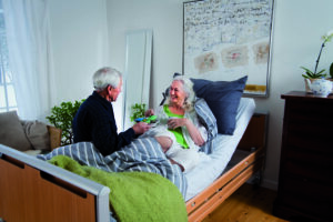 elderly person sitting up on hospital bed at home